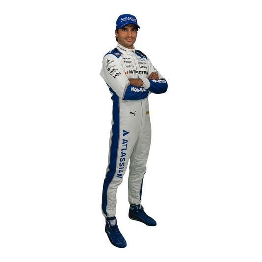 Carlos Side profile wearing a racing 2025 suit with various sponsor logos on a white background