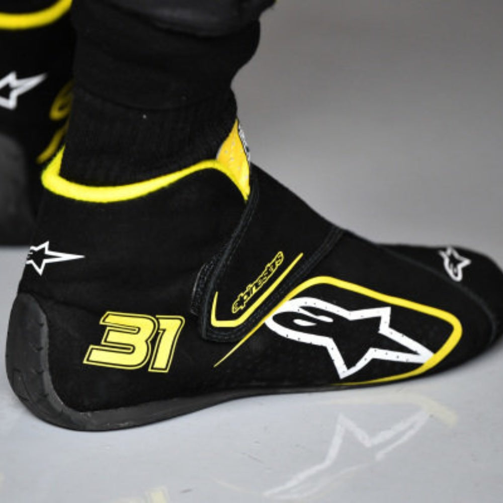 Black and yellow Esteban Ocon 2020 Tuscan GP F1 Racing shoe cover with number 31 and star logo on a gray background