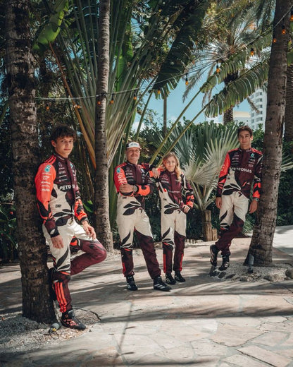 Four people, George, Valtteri, Doriane, and Kimi, in matching 2025 Mercedes Miami GP F1 outfits standing among palm trees.