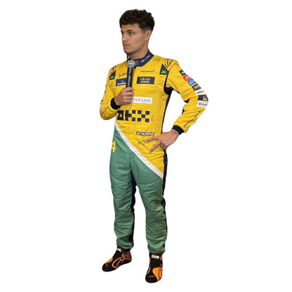 Lando Norris wearing a yellow and green McLaren F1 racing suit in Monaco GP with various sponsor logos on a white background