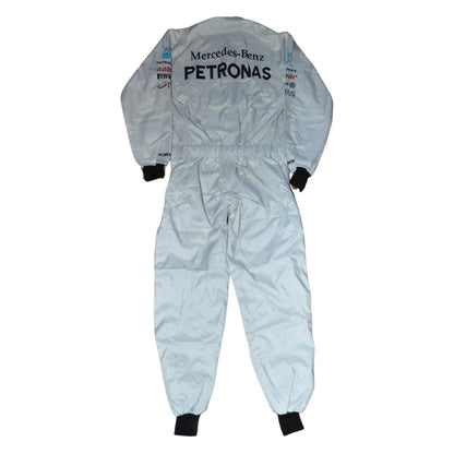 Back view of Schumacher’s 2012 F1 suit showing full-length silver material with contrasting black paneling and his signature logo on the upper back.